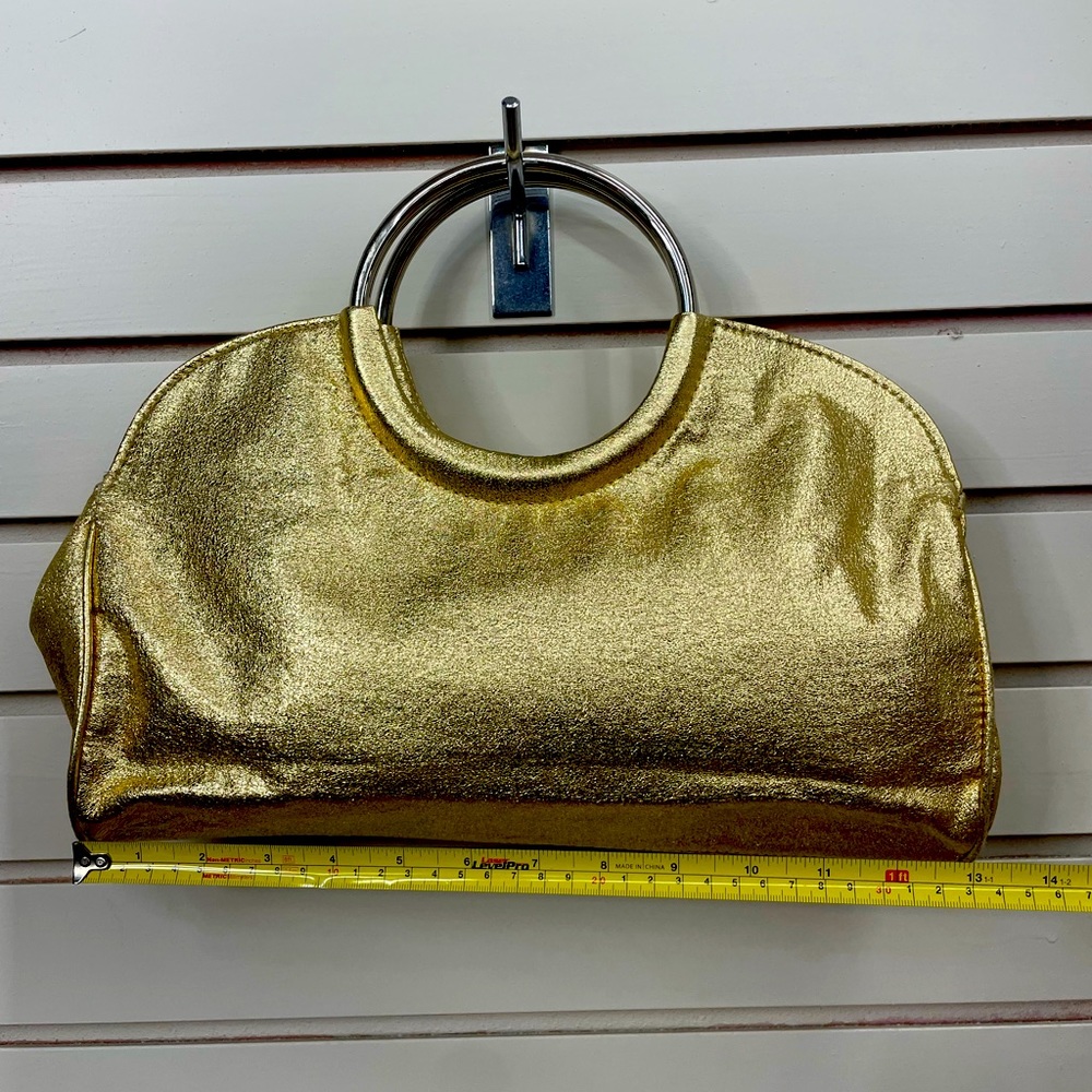 Gold shimmery bag with solid round chrome handles.